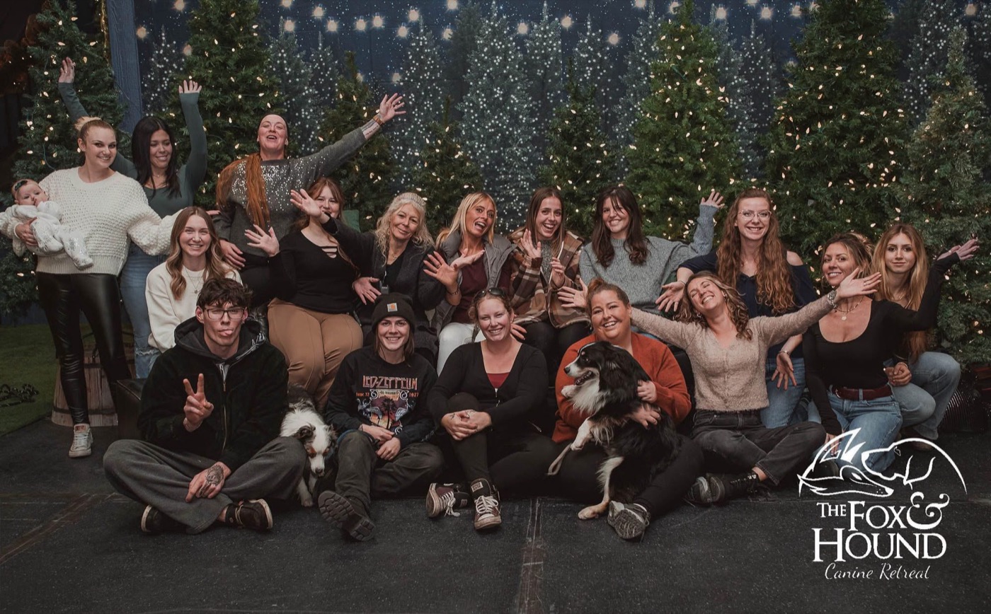 The F&H team posed together in front of a row of lit Christmas trees